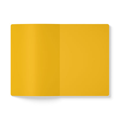 An overhead view of an open creative notebook with blank, bright yellow pages. Centered on a white background, this notebook is perfect for daily journaling, with a soft light casting a gentle shadow at the bottom left edge.