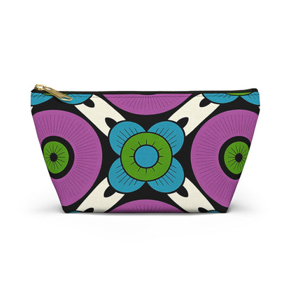 A zippered cosmetic travel bag with a bold, colorful geometric floral pattern. Featuring African-inspired patterns, large blue flowers, purple circles, and black-and-white accents on cream. Gold zipper hardware adds an elegant touch.