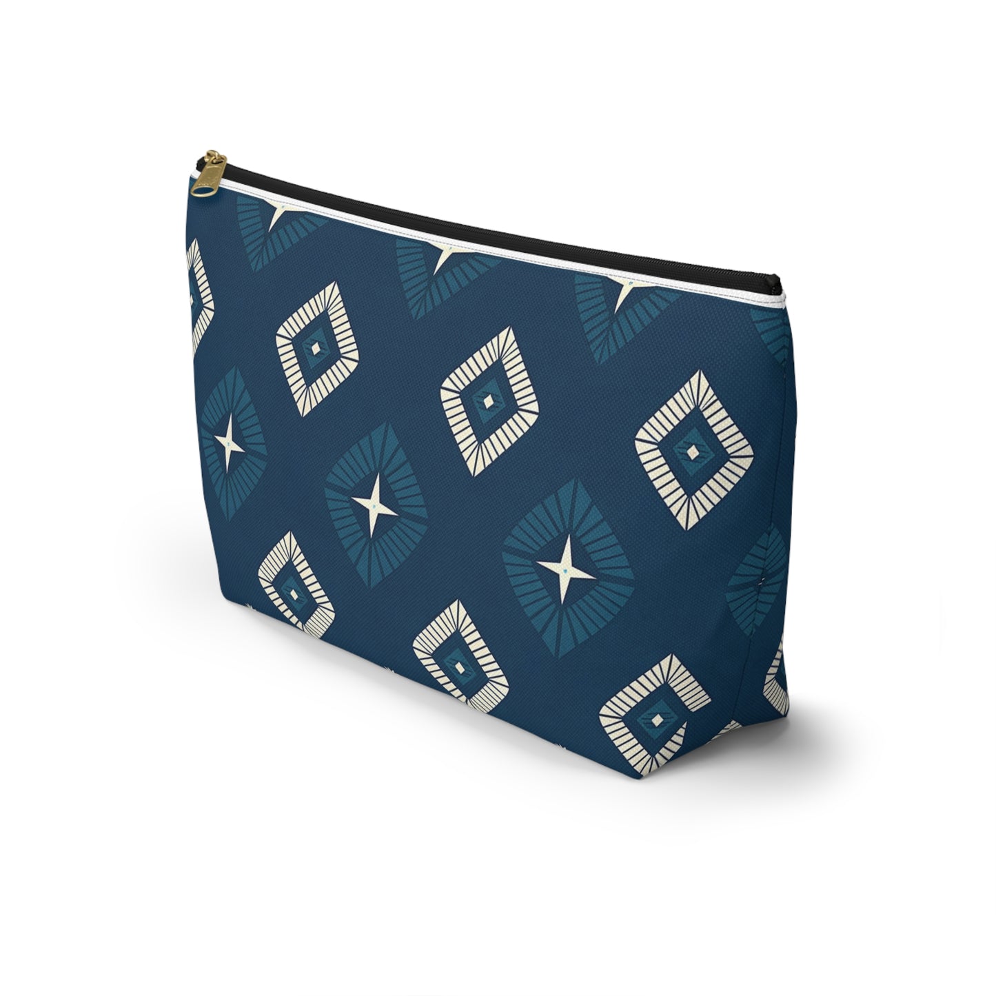 A navy blue T-bottom pouch stands on a white surface, featuring African-inspired geometric patterns of blue and white diamond shapes with central star-like designs. The cosmetic travel bag has a black zipper and a small gold pull tab at the top.