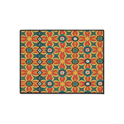 Rectangular mat featuring a vibrant, African-inspired geometric pattern in red, orange, yellow, green, blue, and black. Flower-like shapes and star motifs create a bold kaleidoscopic effect. Includes non-slip rubber backing for added safety.