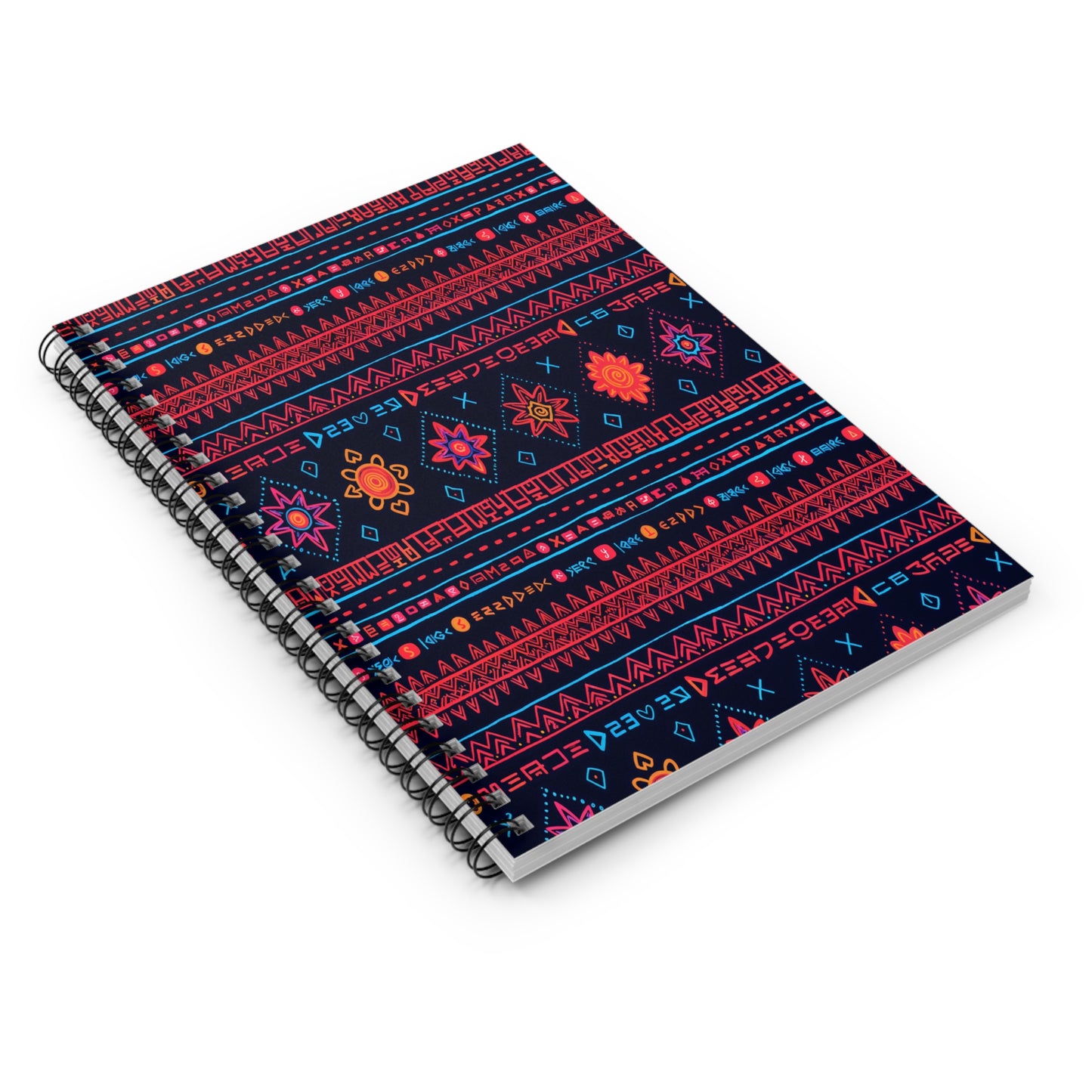 A spiral-bound notebook with a dark background features vibrant geometric and floral patterns in red, pink, orange, and blue. The decorative motifs and culturally inspired designs create a colorful, folk-inspired look on the cover.