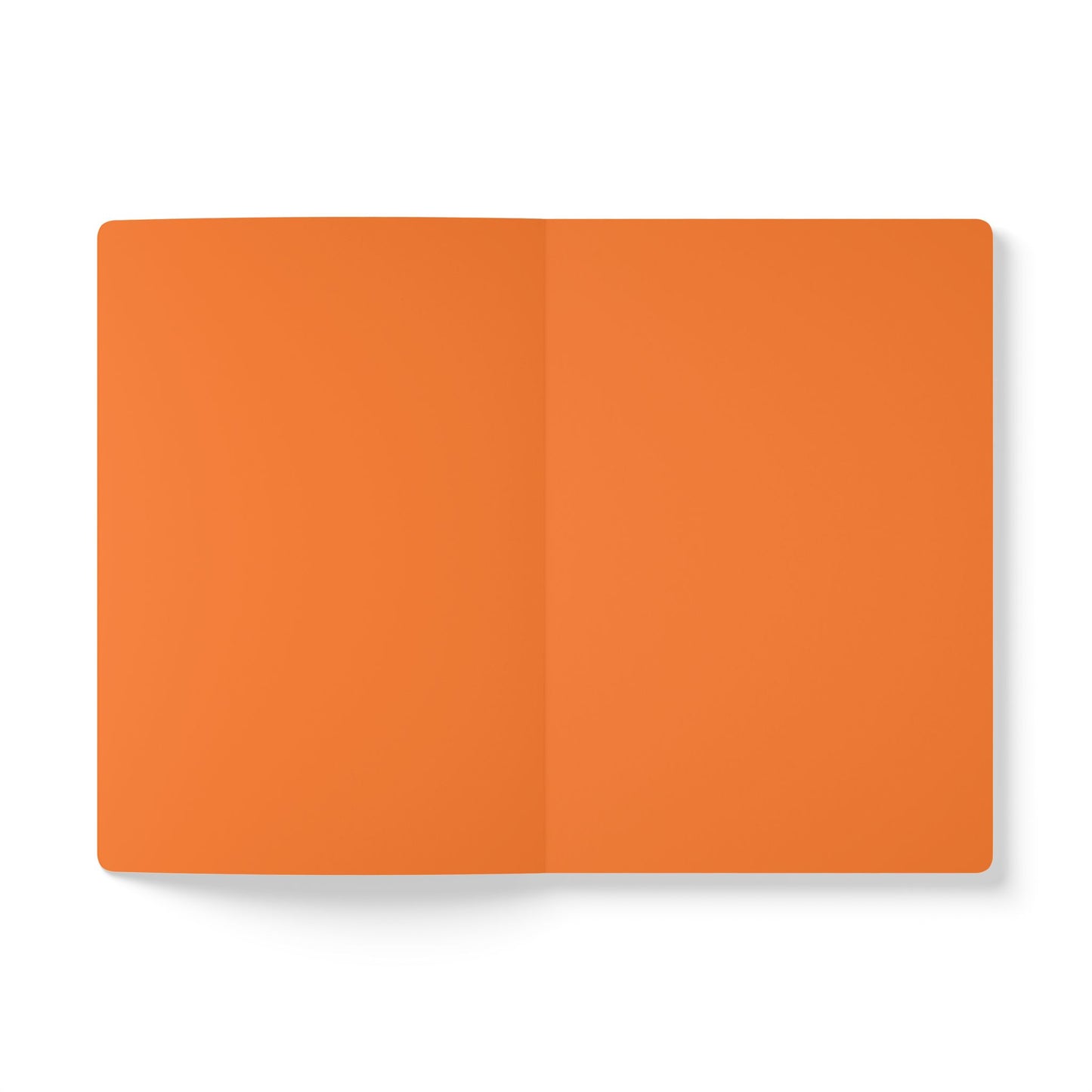 An open, blank creative journal with orange pages lies on a white surface. Viewed from above, a crease shows where the pages are bound. There are no markings, text, or designs, inviting inspiration for daily journaling.