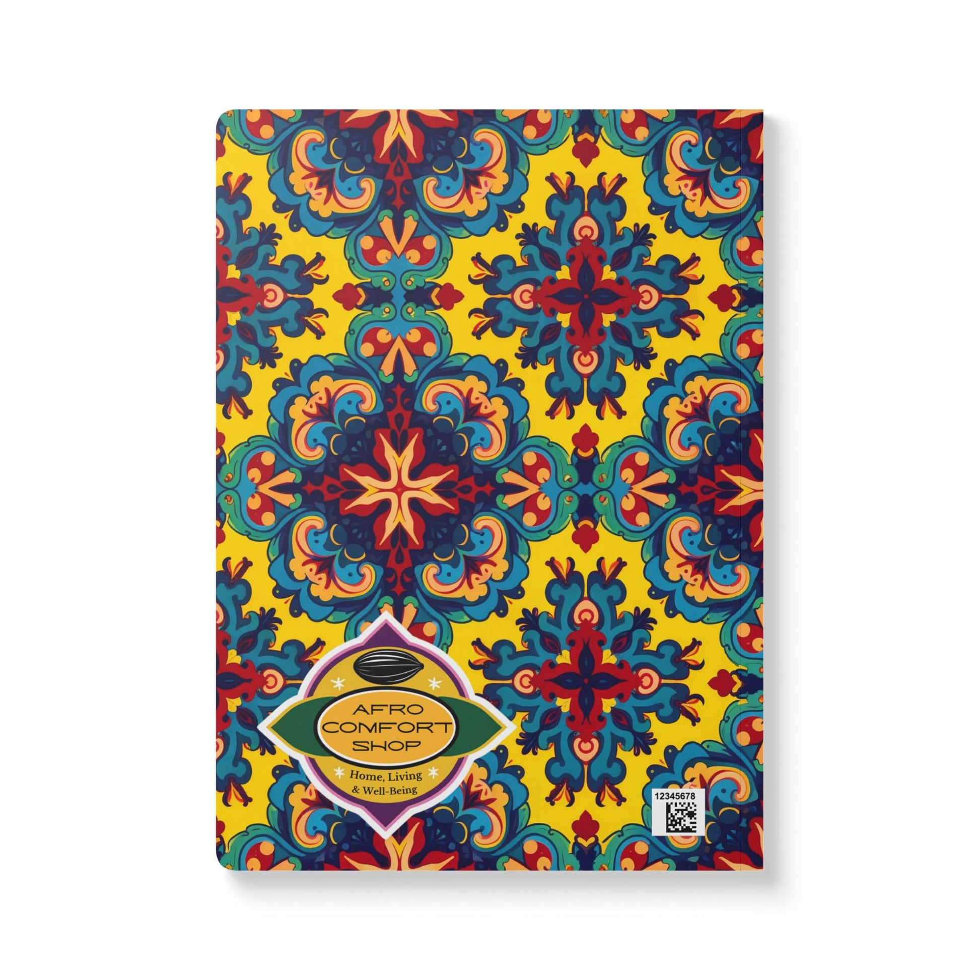 A vibrant African-inspired journal featuring a symmetrical pattern in blue, red, and teal on a yellow background. The gold “AFRO COMFORT SHOP” label and a small QR code add unique touches—perfect for daily journaling or creative notebook ideas.