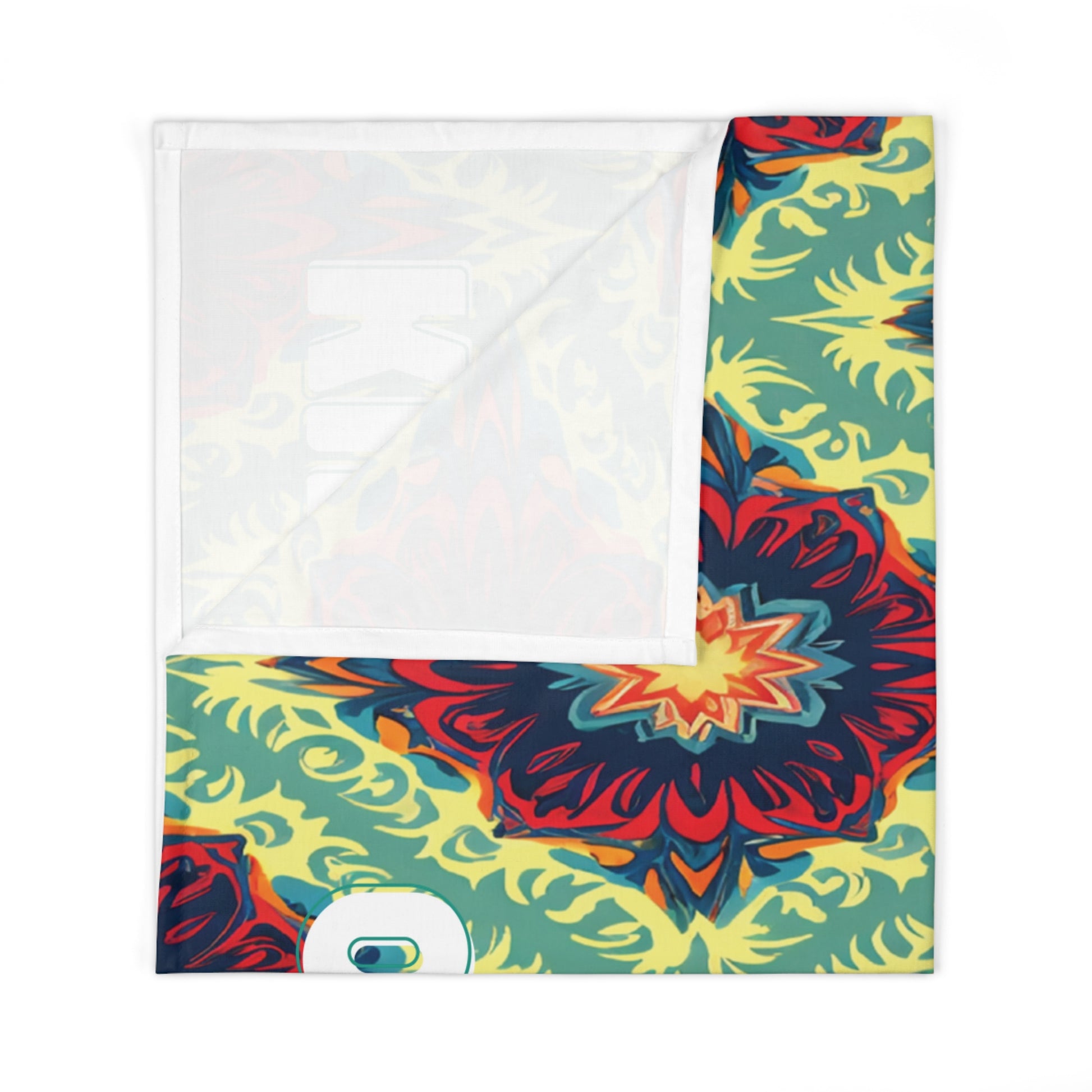 A folded fabric piece with a vibrant mandala pattern, perfect as an African-inspired decor accent. Large, symmetrical shapes in red, yellow, teal, and dark blue radiate from the center; the upper left corner is folded to reveal a white reverse side.