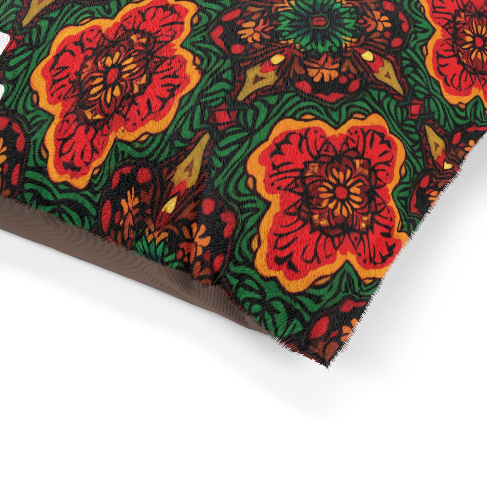 A close-up of a colorful fabric with a bold, intricate floral pattern. Large red and orange flowers are surrounded by green leaves and swirling designs, offering vibrant symmetry—ideal for personalized pet beds with both style and durable construction.