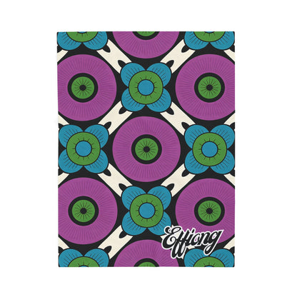 A bold geometric pattern with large purple circles and blue-green floral designs graces this African-inspired personalized blanket. “Effiong” is elegantly scripted in white on a cream and black background—an ideal personalized gift.