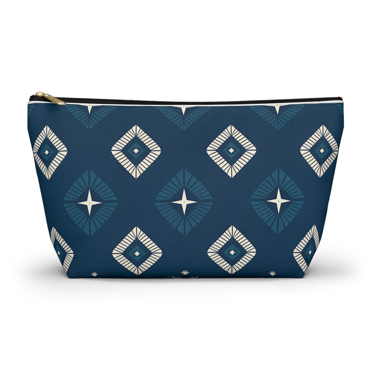 A T-bottom pouch with a navy blue background features a repeating geometric pattern of diamond shapes in shades of blue and white, each with a star-like design in the center. This cosmetic travel bag stands upright, showcasing its wide base and gold zipper.