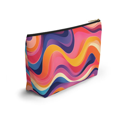 A zippered T-bottom pouch featuring a vibrant, wavy abstract pattern inspired by African-inspired patterns. With swirling bands of pink, orange, yellow, purple, blue, and cream, this cosmetic travel bag offers a colorful and dynamic look. Black zipper with gold pull.