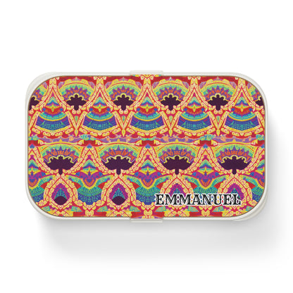 A small rectangular African-inspired bento lunch box with a colorful, intricate geometric and floral pattern in red, yellow, blue, and green. The name EMMANNUEL is printed in bold white and black letters in the lower right corner.