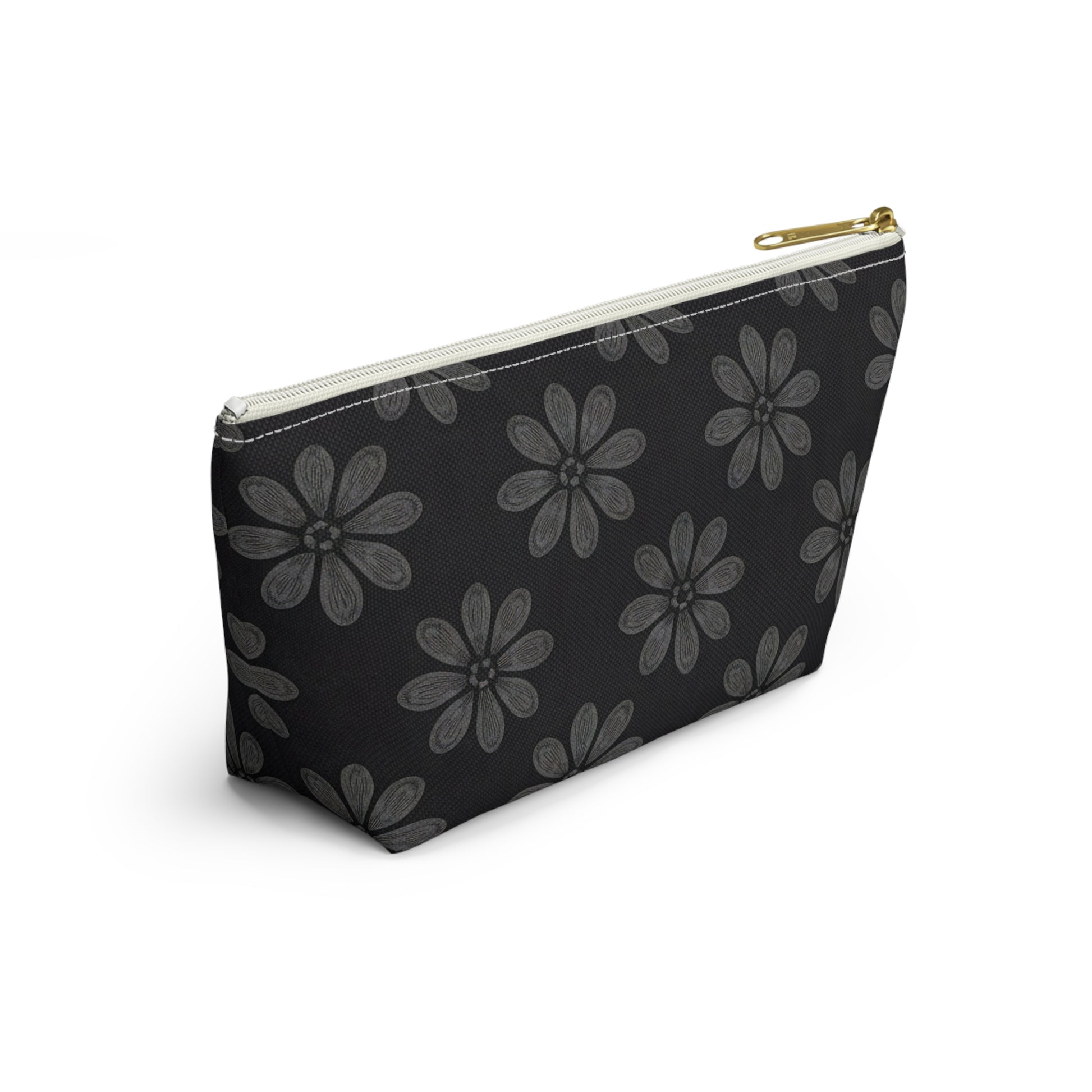 A black T-bottom pouch with a gold zipper pull, featuring a repeating pattern of large, stylized gray flowers reminiscent of African-inspired patterns. The cosmetic travel bag is positioned at an angle on a white background.