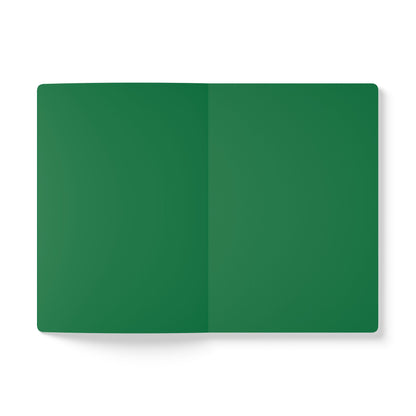 An open African-inspired journal lies flat on a white surface. Both visible pages are completely blank and solid dark green in color, with a subtle crease running vertically down the center where the notebook is folded.