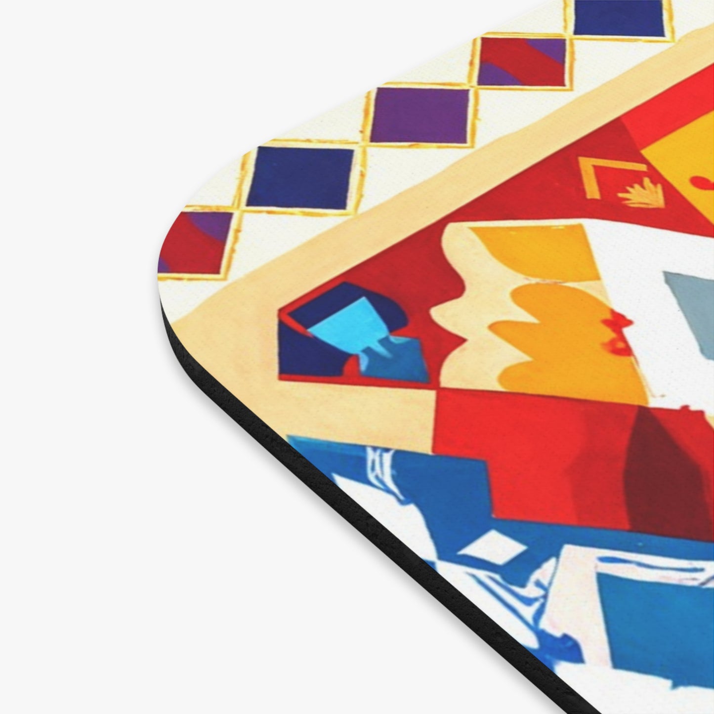 Close-up of an African-inspired mouse pad with a non-slip rubber base, featuring a colorful abstract geometric design in red, blue, yellow, and white. The top left area shows a grid of purple diamonds bordered by yellow lines. The object has a black edge.