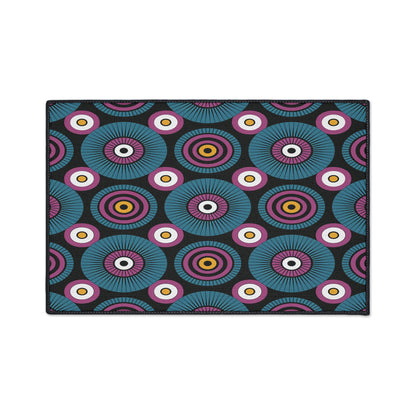 A rectangular mat featuring a repeating geometric pattern reminiscent of African-inspired aesthetics, with concentric circles in teal, purple, yellow, and pink on black. The bold design pops on custom floor mats with non-slip rubber backing.