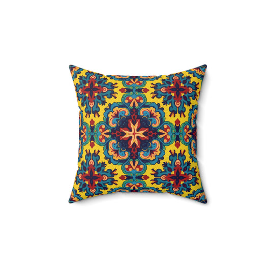 Square decorative faux suede pillow with a symmetrical, ornate pattern in blue, red, green, and orange on a bright yellow background. This African accent pillow features floral and mandala-like shapes radiating from the center for a vibrant look.