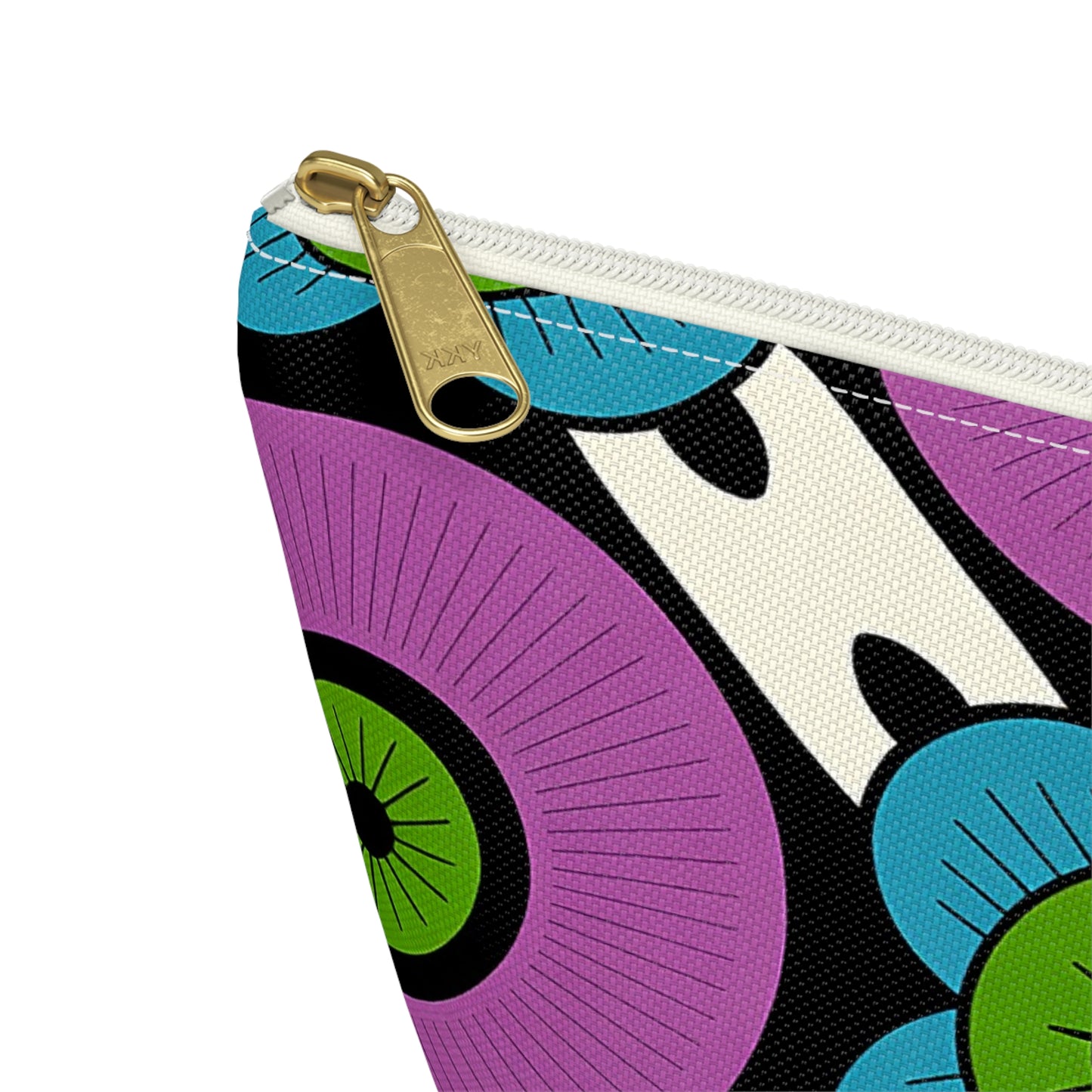 Close-up of a T-bottom pouch with a gold zipper, featuring a bold, retro-inspired pattern of concentric circles in purple, green, and black with blue floral accents on white canvas. African-inspired patterns add flair to this unique cosmetic travel bag.