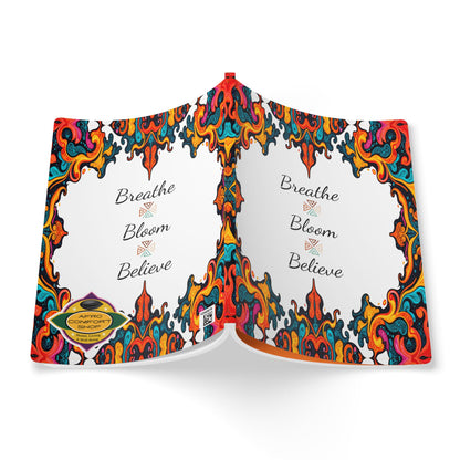 An open creative journal with a colorful, swirling abstract border in red, orange, blue, and yellow. The center pages say “Breathe, Bloom, Believe” in elegant script. A gold Carbon Neutral badge is on the bottom left corner of the cover.