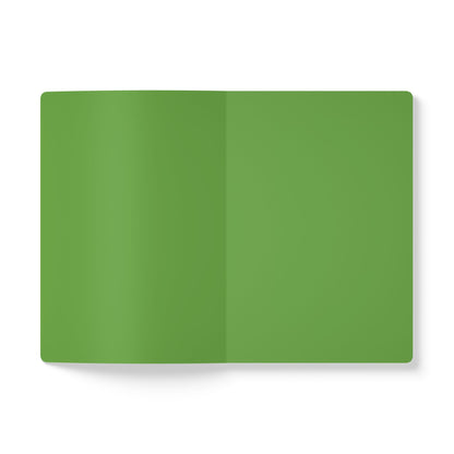 A top-down view of an open African-inspired journal or notebook with blank, solid green pages. The background is white, and there are no visible text, images, or markings. The shadows suggest a slight curve at the book’s spine.