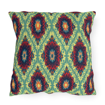 Square pillow with a vibrant, African-inspired geometric pattern featuring symmetrical floral medallions in red, navy, yellow, and green. The light green background with yellow leafy shapes forms a repeating diamond design across the fabric.