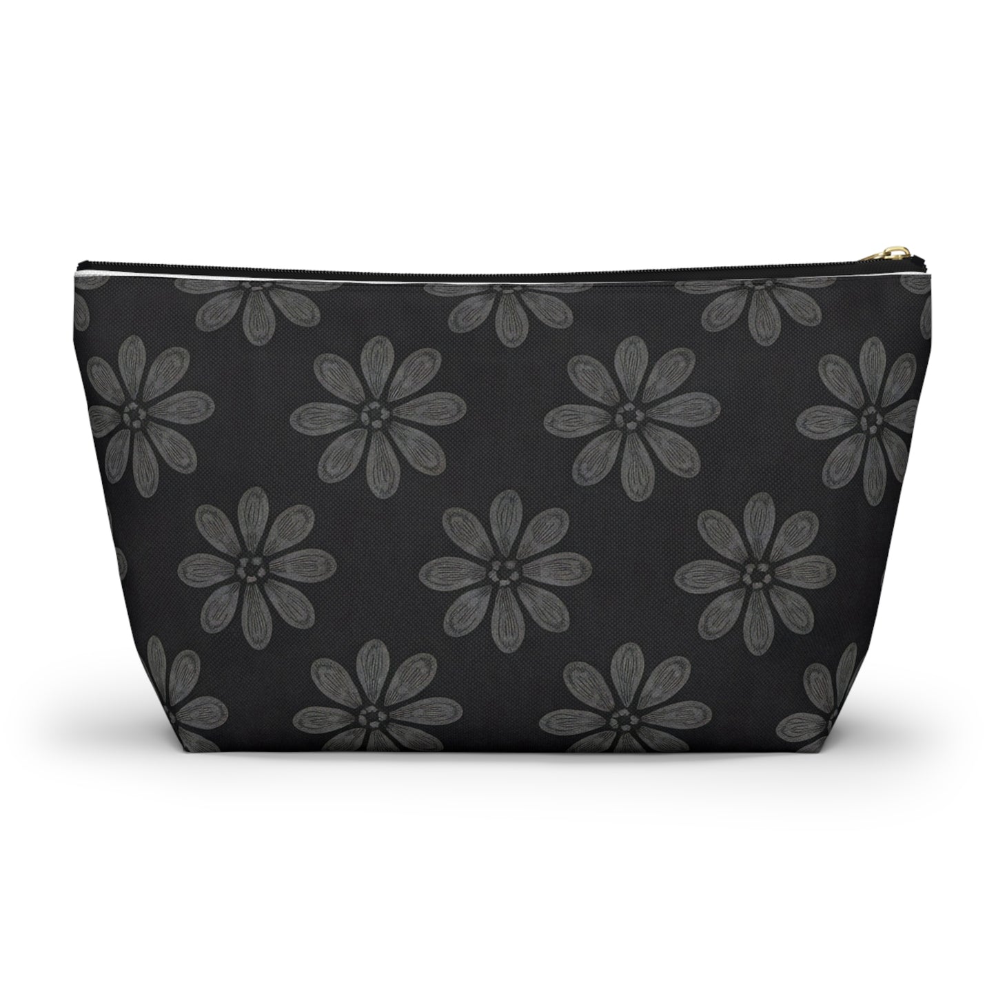 A black cosmetic travel bag featuring a repeating pattern of hand-drawn, grey six-petal flowers with subtle shading. This T-bottom pouch has a wide base, tapers toward the top, and closes with a gold-colored zipper on its solid black background.