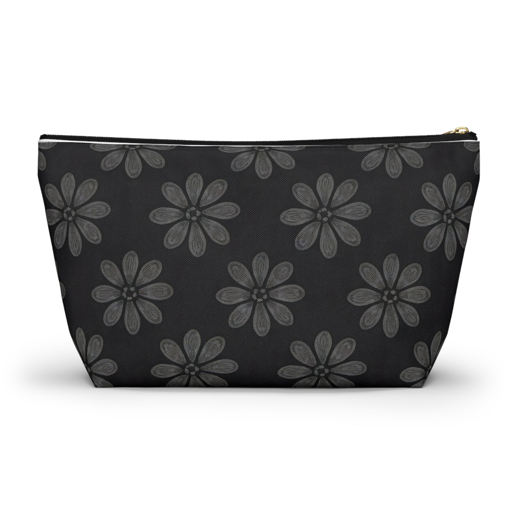 A black cosmetic travel bag featuring a repeating pattern of hand-drawn, grey six-petal flowers with subtle shading. This T-bottom pouch has a wide base, tapers toward the top, and closes with a gold-colored zipper on its solid black background.