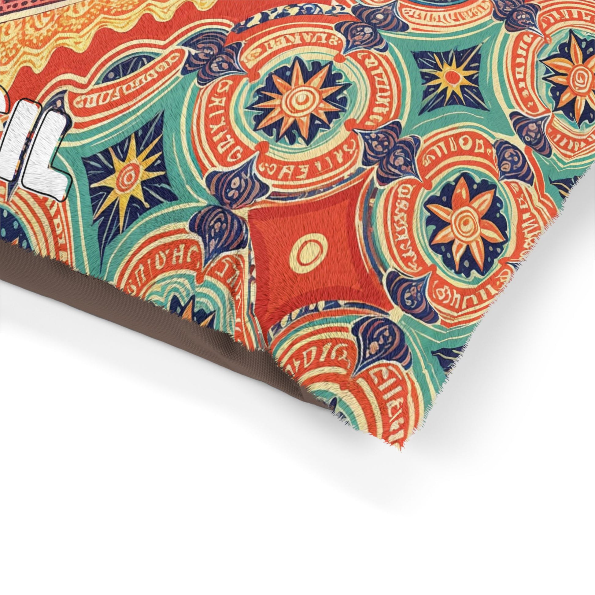 A close-up of a decorative pillow corner with a vibrant, intricate pattern of circular, star-like shapes in orange, green, blue, and red. Part of the word “EVIL” in bold white letters is visible—perfect for a stylish dog bed or personalized pet bed accent.