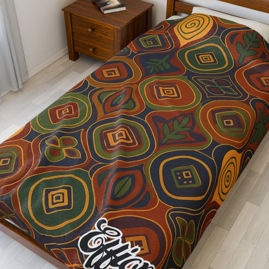 A twin bed features an African-inspired blanket with a colorful geometric abstract pattern in red, green, yellow, brown, and blue. The word Elfin is written in white script at the corner—perfect as a unique custom gift.