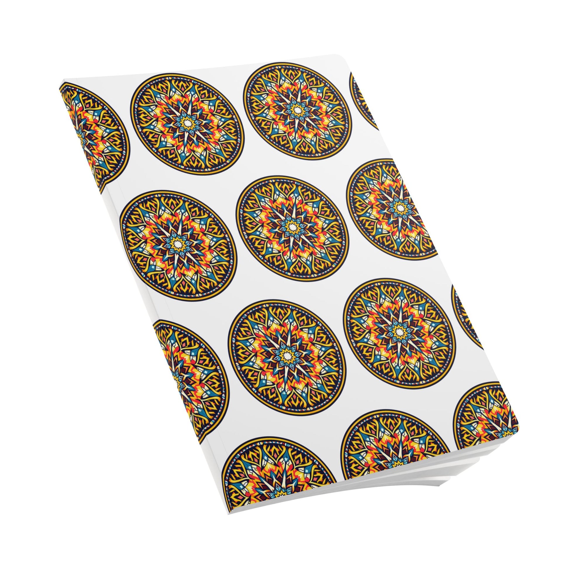 A softcover notebook with a white cover featuring a repeating pattern of colorful, intricate, circular mandala designs in orange, yellow, blue, and black. Perfect for creative journaling, it’s shown at an angle on a plain white background.