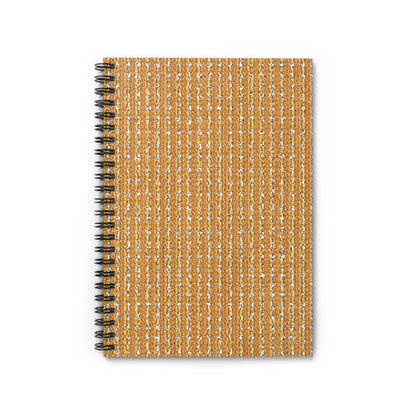 A top-down view of an African-inspired spiral notebook with a textured, woven tan and white cover. The cover features vertical stripes with a subtle shimmer, and the black metal spiral binding is visible on the left side against a white background.