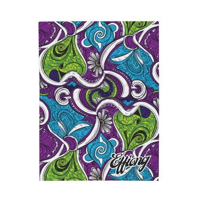 A vibrant notebook cover features an intricate, swirling paisley pattern in green, blue, purple, and white—reminiscent of an African-inspired blanket. Black outlines accentuate the abstract floral and leaf shapes. “Effiang” is printed in bold white script at the bottom right corner.