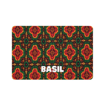 A rectangular, African-inspired label with BASIL in bold white letters centered at the bottom. The background features a vibrant, intricate pattern of red, orange, and green floral and geometric shapes on a dark background.