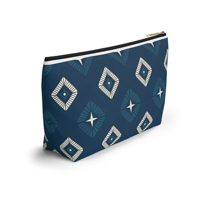 A rectangular T-bottom pouch with a dark blue background, adorned with African-inspired patterns of geometric diamonds in white and light blue. Each diamond has a central starburst design. Perfect as a cosmetic travel bag, it features a gold zipper and black lining.
