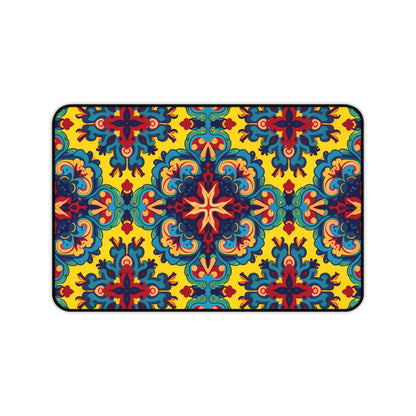 A rectangular Neoprene desk mat with an intricate, symmetrical floral pattern in red, blue, teal, and orange on a bright yellow background. This ergonomic desk mat adds a kaleidoscopic flair as a colorful workspace accessory within a thin black border.
