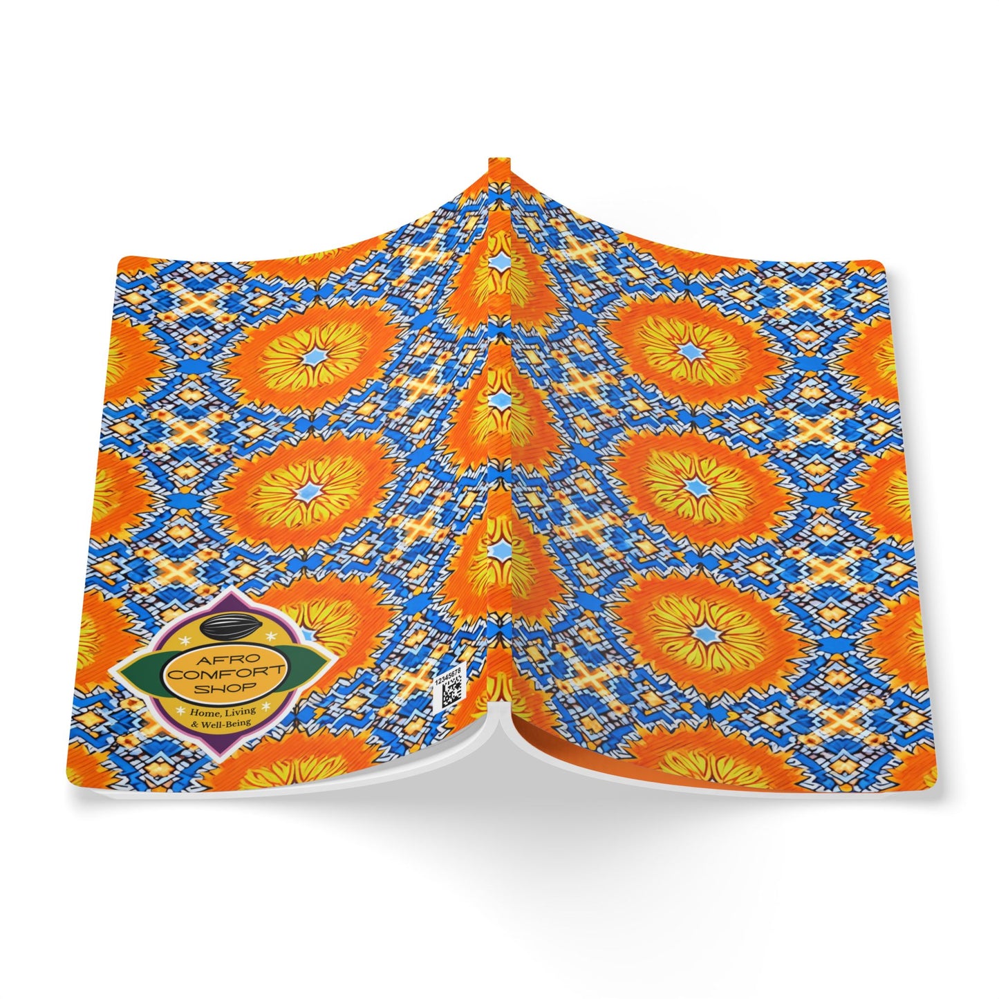 A colorful fabric is draped open, featuring a bold pattern of orange and yellow sunburst flowers with blue and white geometric shapes—perfect inspiration for an African-inspired journal. A yellow diamond-shaped label reads “AFRO COMFORT SHOE.” White background.