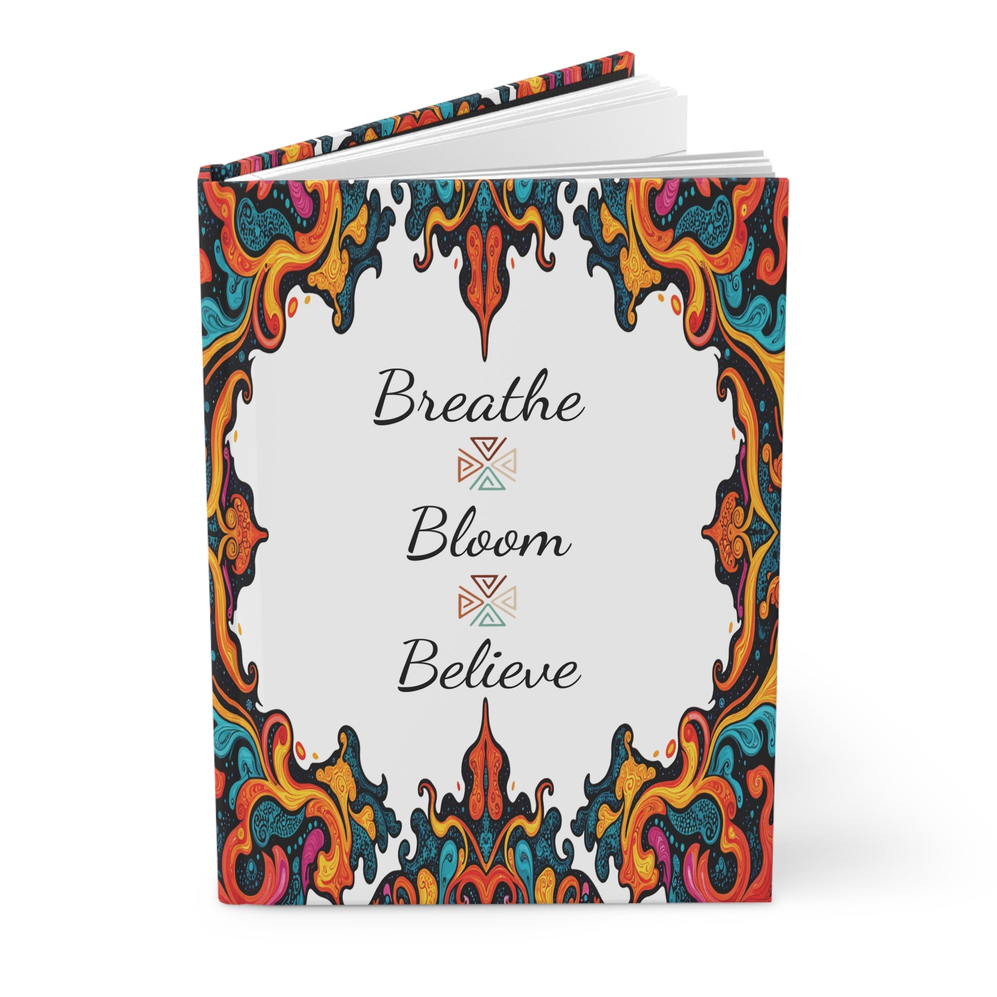 An African-inspired hardcover journal featuring a colorful, swirling ornate border in red, orange, yellow, blue, and black. The center reads “Breathe,” “Bloom,” and “Believe” in elegant script—perfect for your daily wellness ritual.