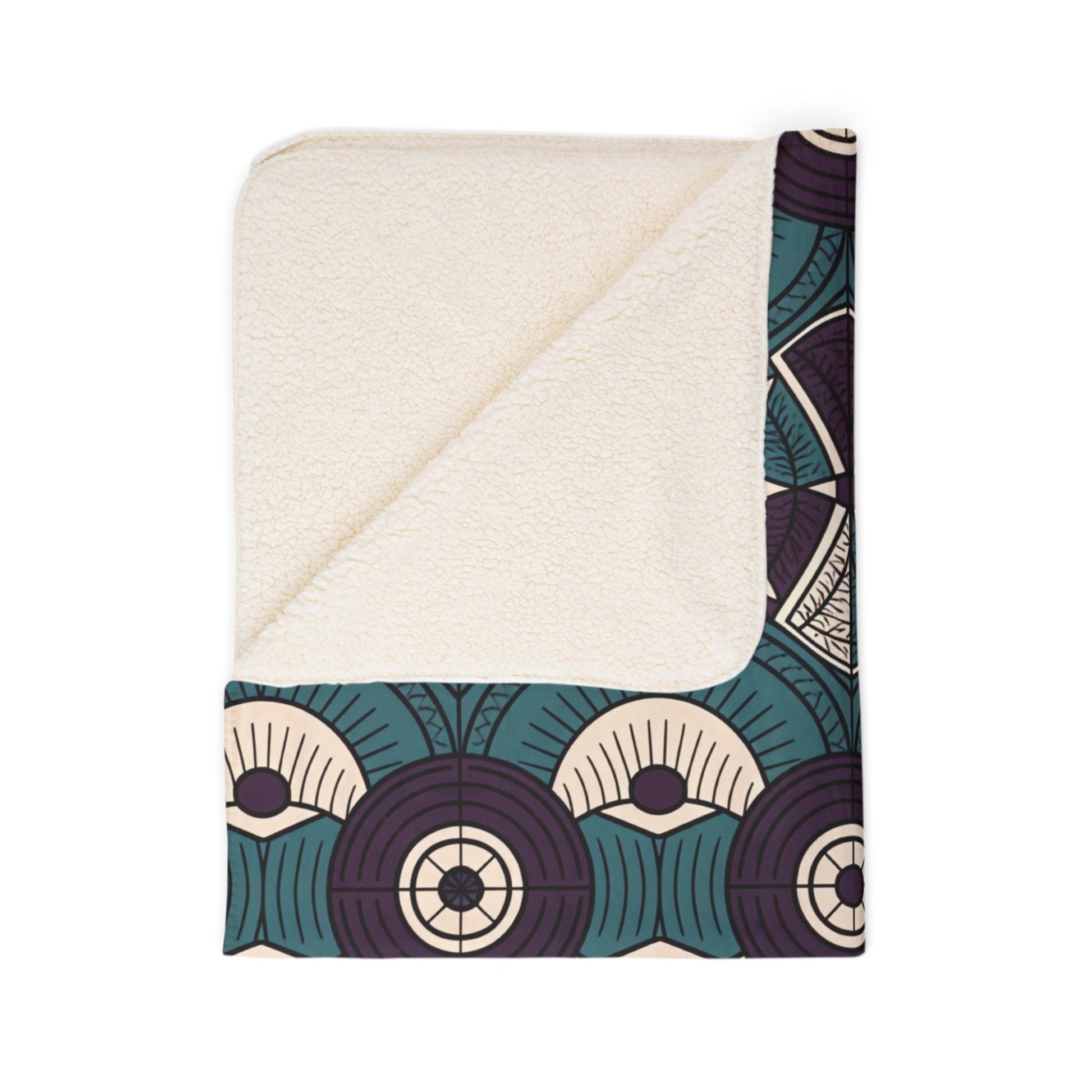 A folded sherpa fleece blanket with a cream-colored, soft fleece underside and a corner flipped over. The top side features an Art Deco-inspired geometric pattern in teal, ivory, and dark purple—perfect for cozy home decor.