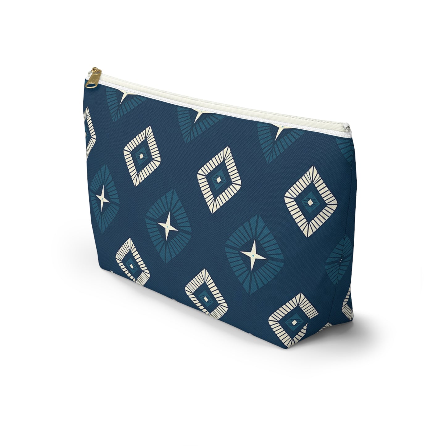A T-bottom pouch with a dark blue background features African-inspired patterns of geometric diamond shapes in white and light blue, each with a central star motif. This cosmetic travel bag stands upright and casts a soft shadow on a white surface.