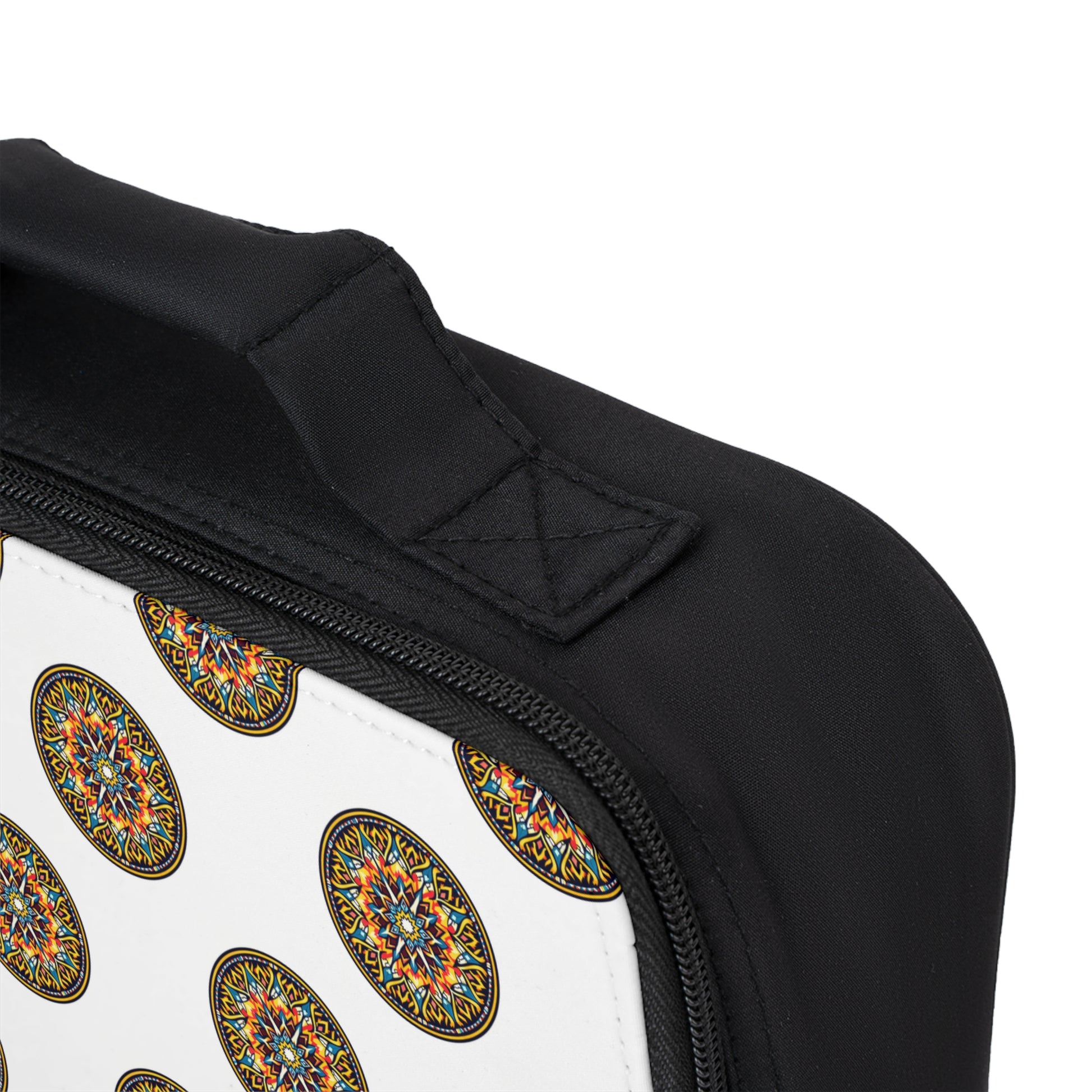 Close-up of an African-inspired lunch bag with a white section featuring a repeating colorful, circular mandala-like pattern. The image highlights the black zipper, stitched handle, and part of the curved edge against a plain background.