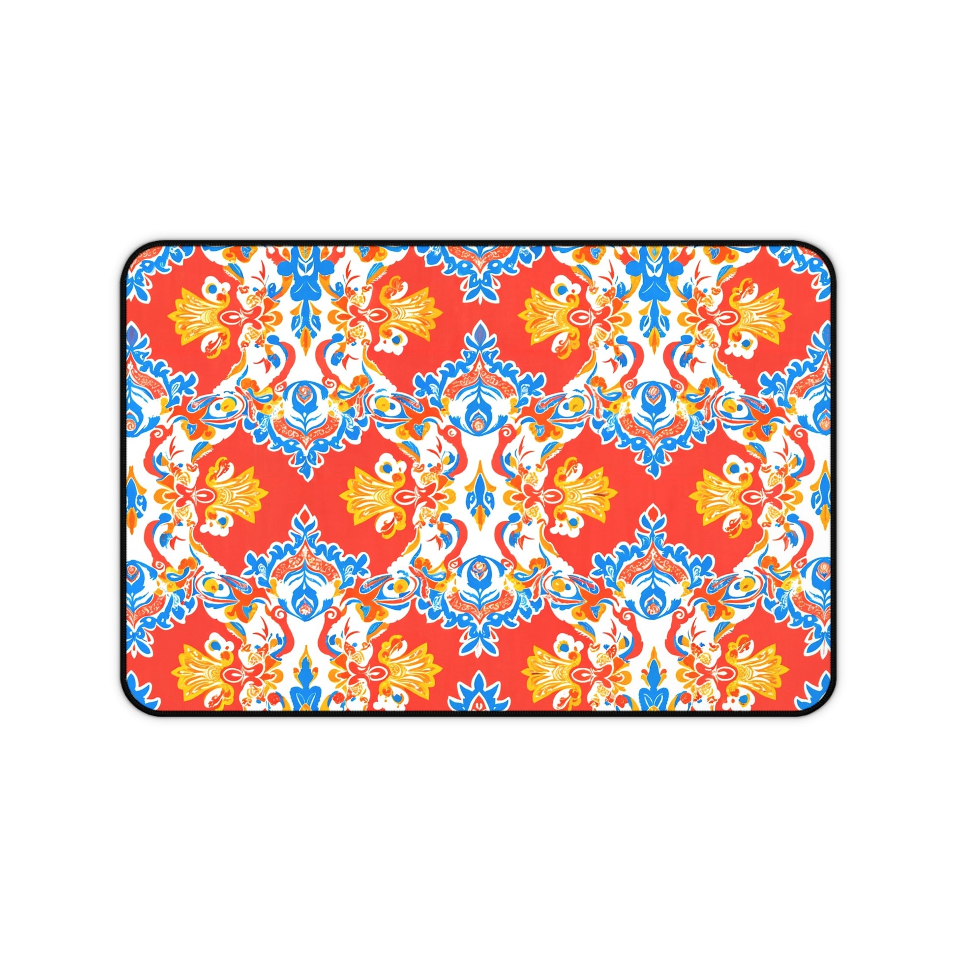 Rectangular neoprene desk mat with a bold red background features an ornate, symmetrical floral and vine pattern in blue, yellow, and white. This vibrant, Mediterranean-inspired non-slip desk pad is a perfect colorful workspace accessory.