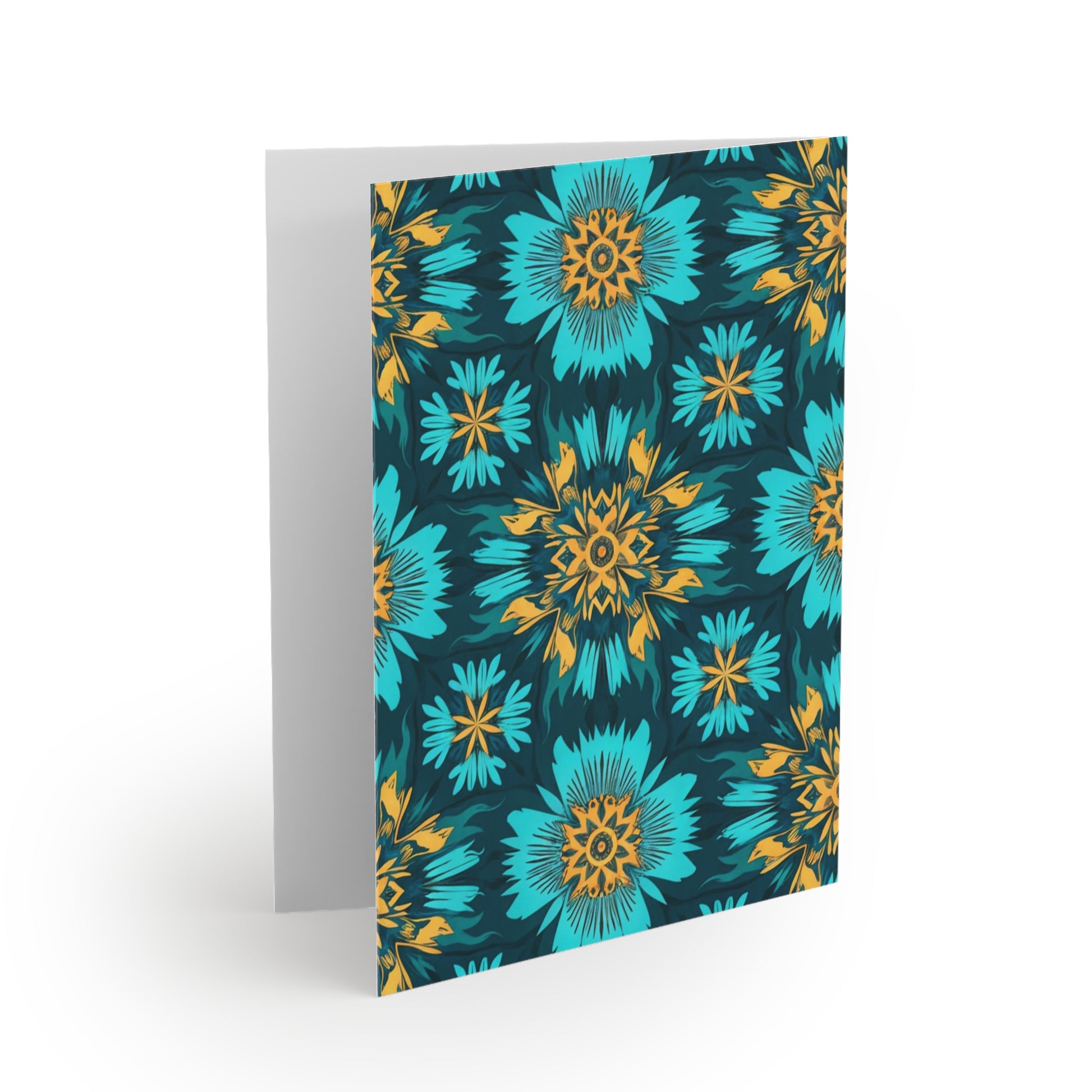 A greeting card stands open with a vibrant floral pattern on the front, inspired by African-inspired greeting cards. Blue and teal flowers with yellow and orange centers stand out against a dark background; the inside is blank and white.