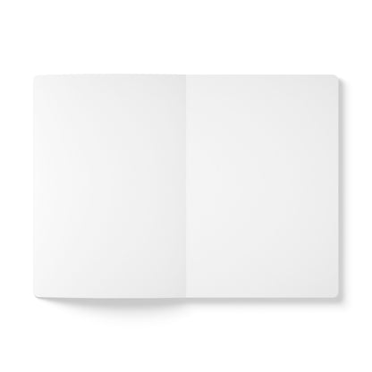 An open blank notebook, perfect for daily journaling or as a creative journal, is laid flat on a white surface. Both pages are empty, with soft shadows along the left edge, highlighting its clean, minimal, and uncluttered appearance.