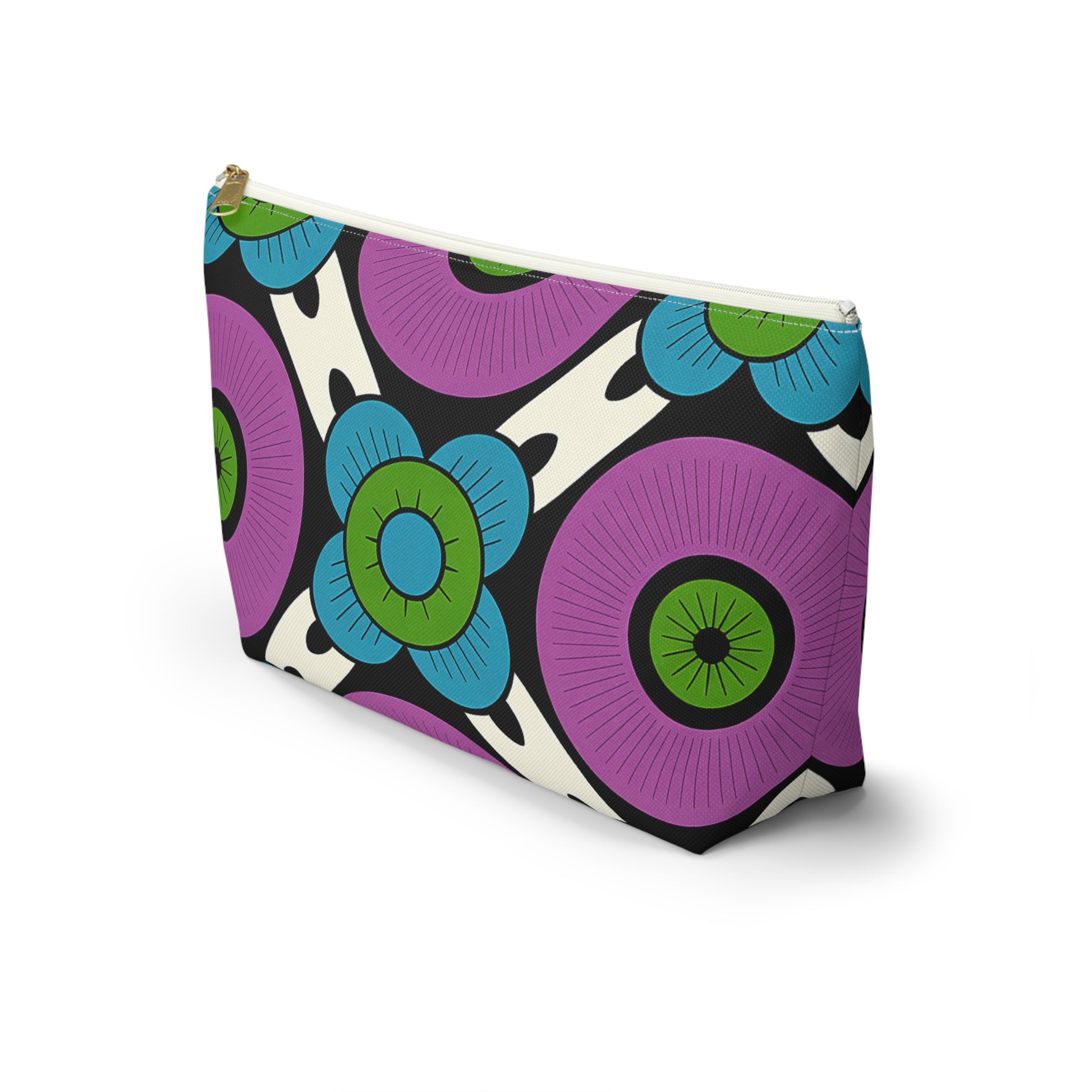 A T-bottom pouch with a bold, retro floral pattern featuring large purple circles and blue flowers with green centers, inspired by African-inspired patterns, set against a white and black abstract background. The zipper is white with a gold pull tab.