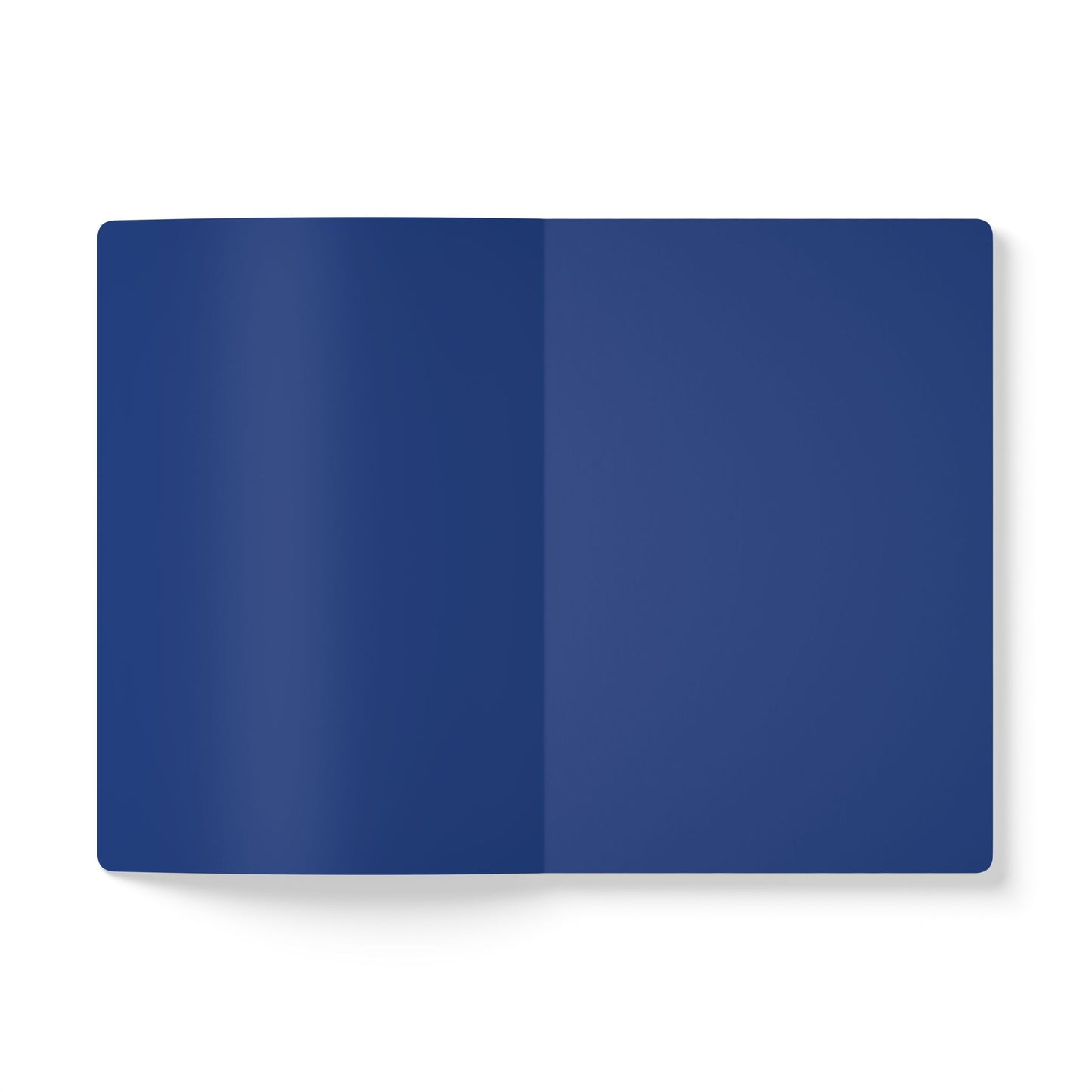 An open creative journal lies flat on a white background, displaying two adjacent blank pages in a solid, deep blue color. The notebook has rounded corners and casts a faint shadow on the left side. No text or markings are visible.