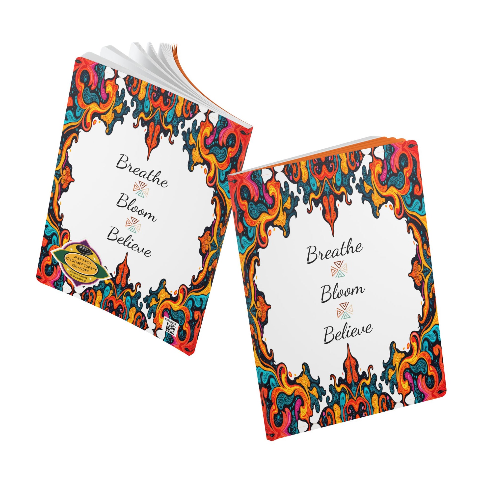 Two colorful books with ornate, swirling red, yellow, and blue borders on white covers evoke an African-inspired journal style. “Breathe Bloom Believe” appears in cursive above small flowers. One book is open for daily journaling; both rest on a white background.