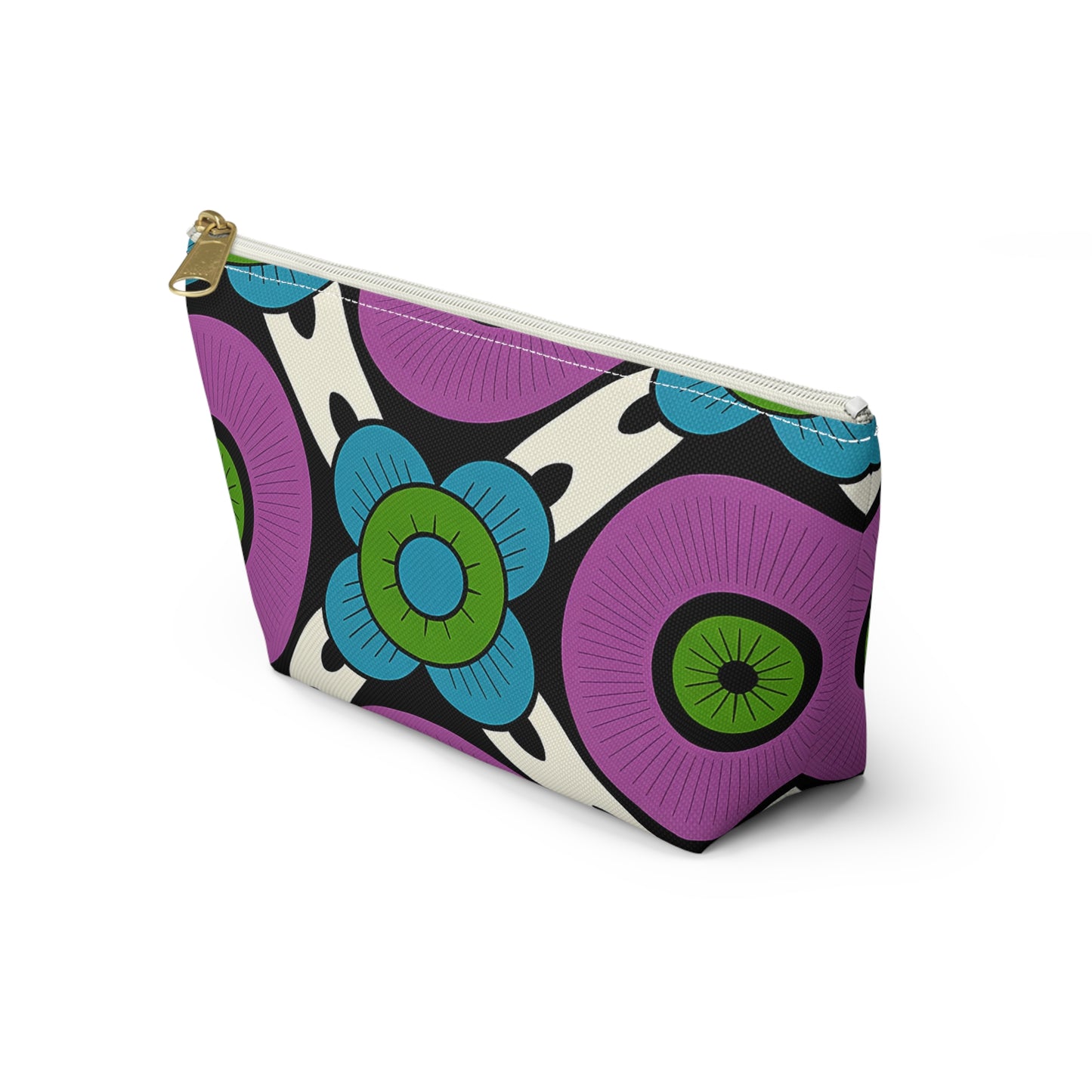 A rectangular cosmetic travel bag with a gold zipper, featuring bold African-inspired patterns in purple, blue, green, and black on a cream background. The design showcases large stylized flowers with circular centers and petal shapes.
