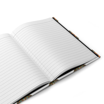 An open, lined hardcover journal with a colorful, patterned cover lies on a white surface. The edges showcase a vibrant, African-inspired geometric design, and the bleed-resistant pages are blank with evenly spaced horizontal lines.