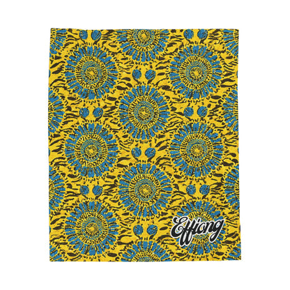 A vibrant African-inspired blanket with blue and teal circular flower shapes outlined in black, set against a bright yellow background with brown streaks. “Effiong” appears in bold white script, perfect as a custom name blanket for any space.