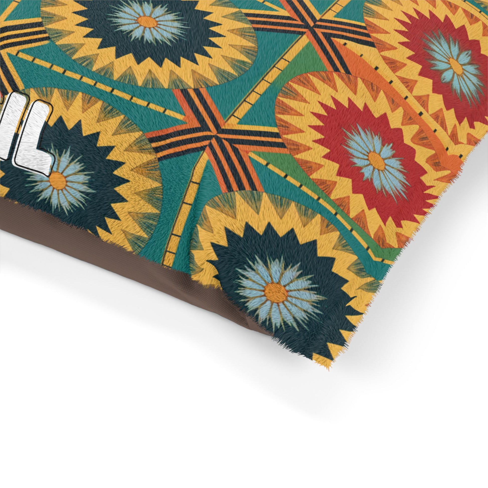 A close-up of a fabric or textile featuring a bold, colorful geometric and floral pattern with circular flower designs in blue, red, and yellow, intersecting lines, and a textured, stitched look—ideal for luxurious comfort on personalized pet beds. The edge of white text is partially visible on the left.
