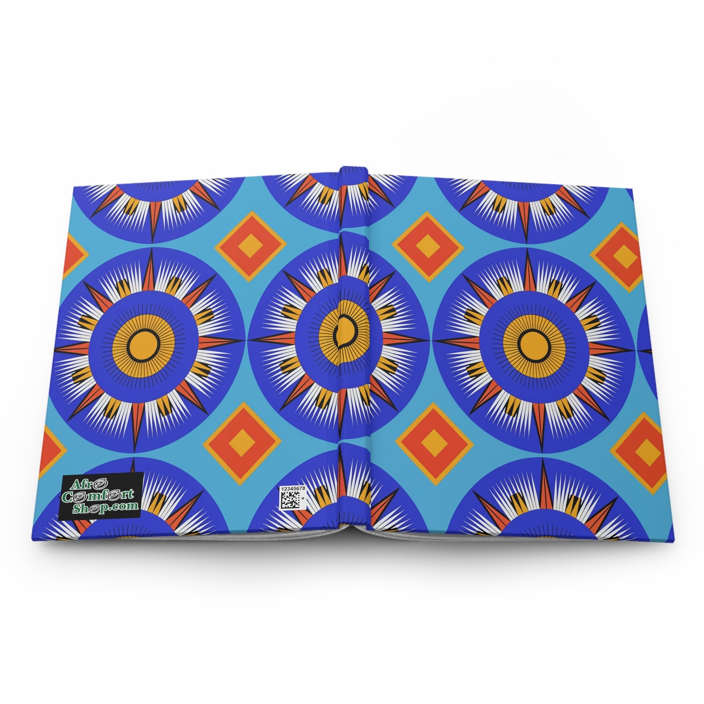 An open hardcover journal notebook displays a vibrant geometric pattern with blue, orange, and yellow circular starburst shapes and orange diamond motifs on a light blue background. The bottom left cover features a black label with white and yellow text and a QR code nearby.