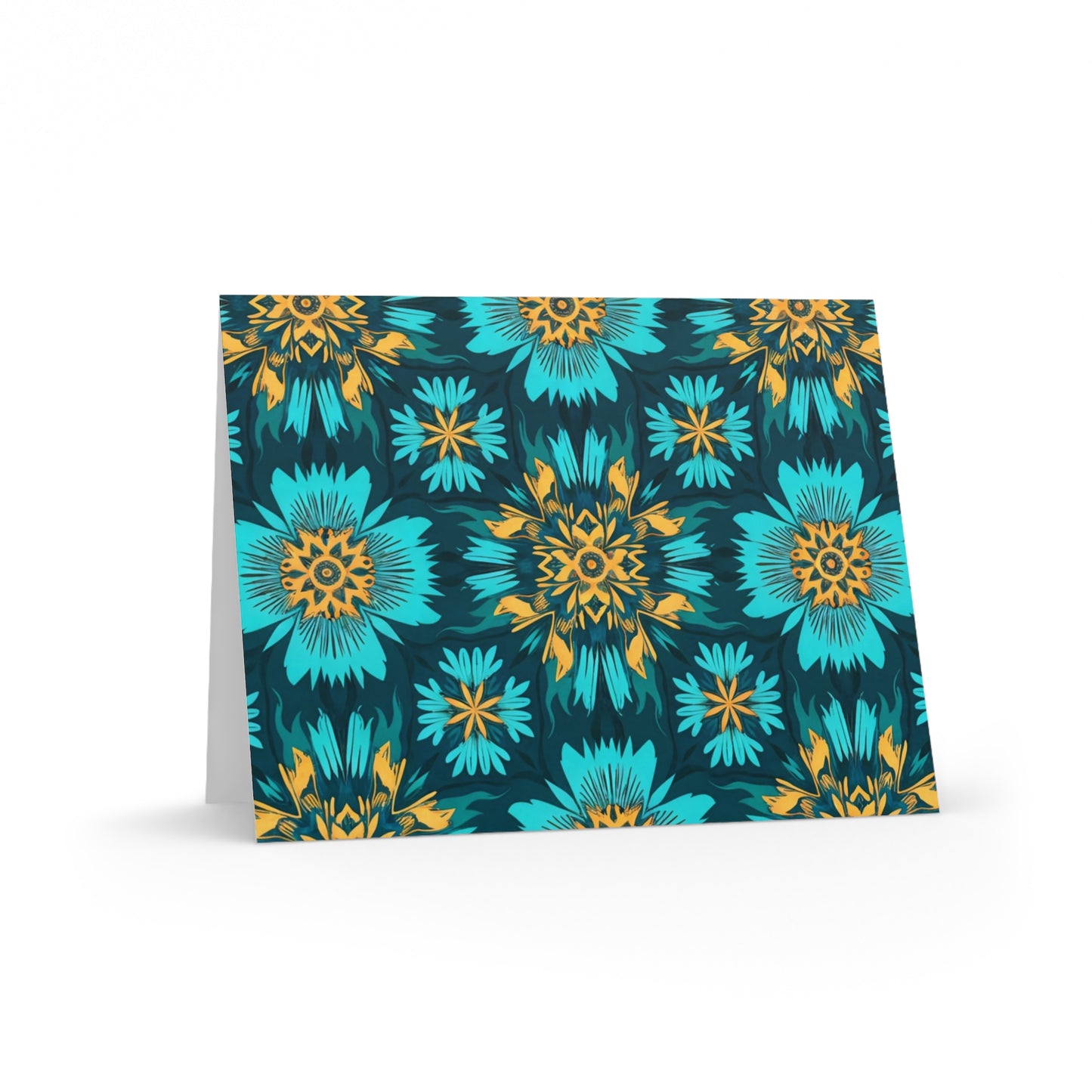 A folded card stands upright, featuring a vibrant floral pattern with large teal and blue flowers and smaller yellow-orange details on a dark background. The geometric, symmetrical design evokes African-inspired greeting cards for a bold, eye-catching appearance.