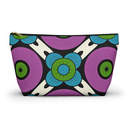 A zippered T-bottom pouch featuring a bold, geometric floral design. Large circular flowers in purple and blue with green centers, outlined in black on a cream background, give this cosmetic travel bag an African-inspired pattern flair.